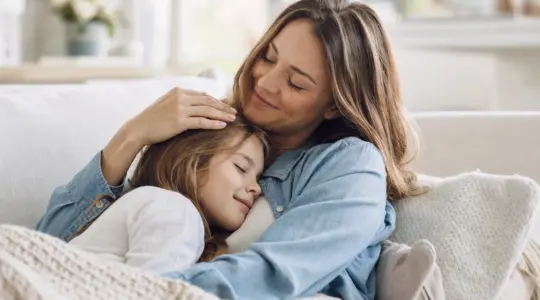 Elternteil und Kind kuscheln liebevoll und vertraut
