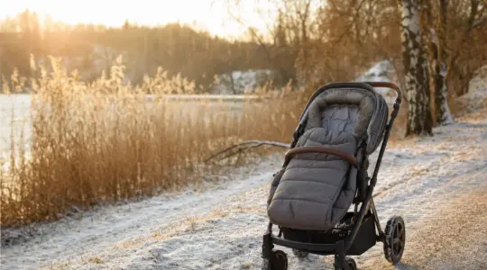 Kinderwagen mit Winterfußsack im Schnee