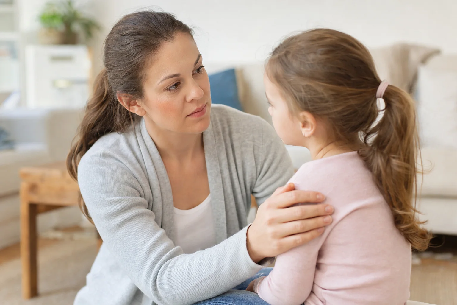Mutter geht auf Augenhöhe und sucht ruhig den Blickkontakt mit ihrem Kind