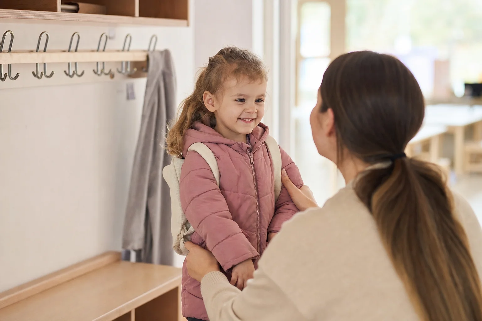 Elternteil bringt vertrauensvoll das Kind in die Betreuung
