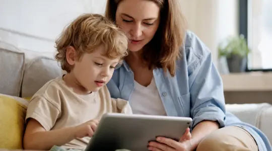 Elternteil und Kind nutzen gemeinsam begleitet ein Tablet