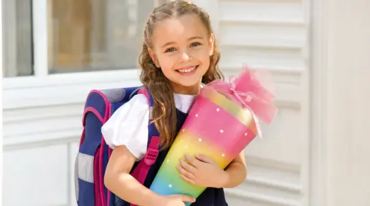 Strahlendes Kind mit Schultüte am ersten Schultag