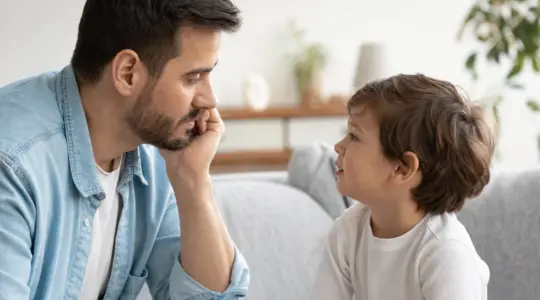 Elternteil und Vorschulkind sprechen nachdenklich miteinander