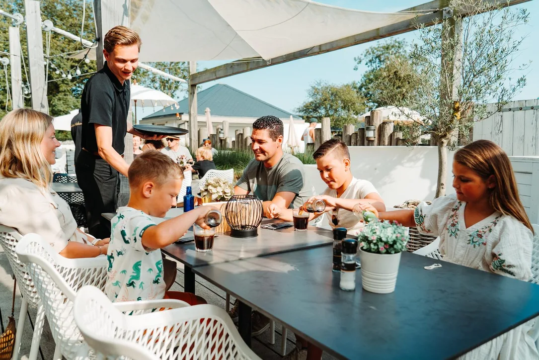 Familie auf der Restaurant-Terrasse bei Camping Zonneweelde
